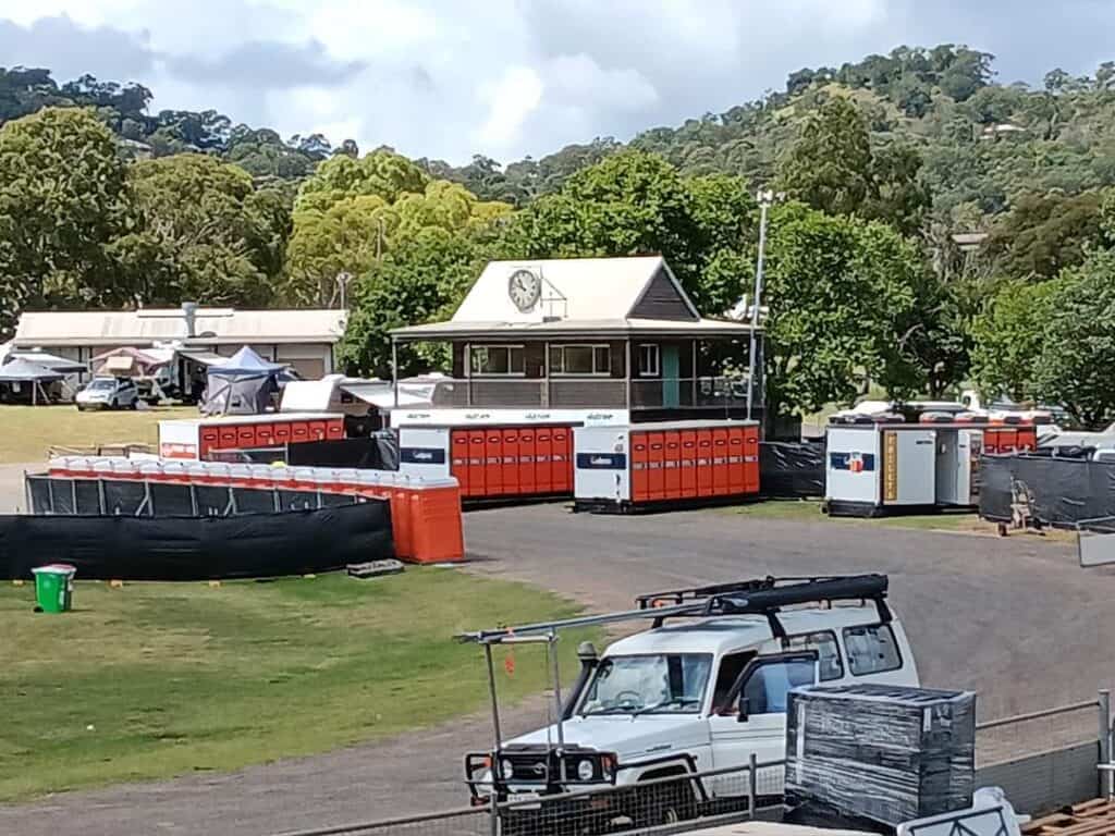 Event set up at local show ground with orange portable toilets and land cruiser ute in the background